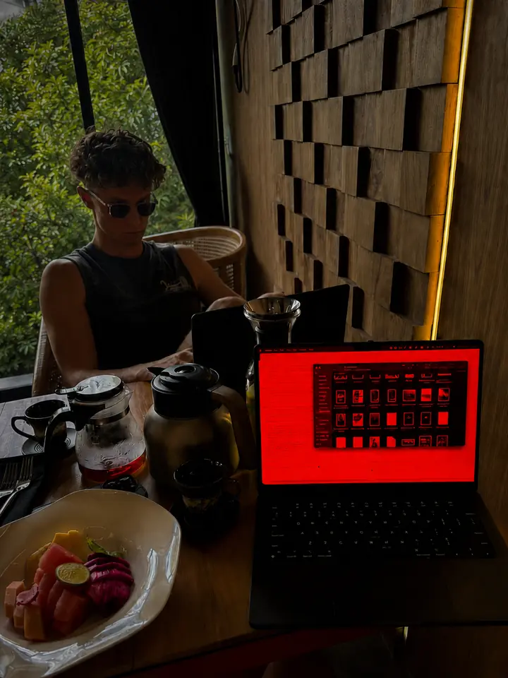 Jack Richards, who makes Sundown, working at a cafe table with his MacBook screen warmed to deep red